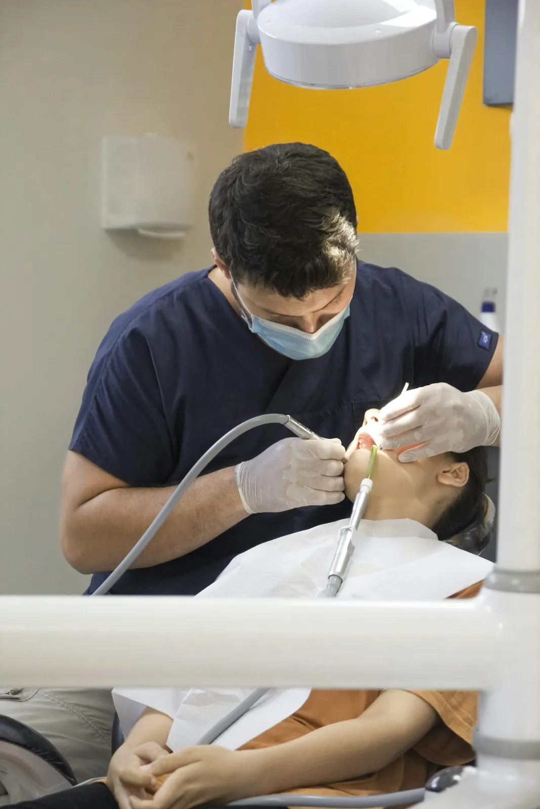 A dentist working with a patient in the chair