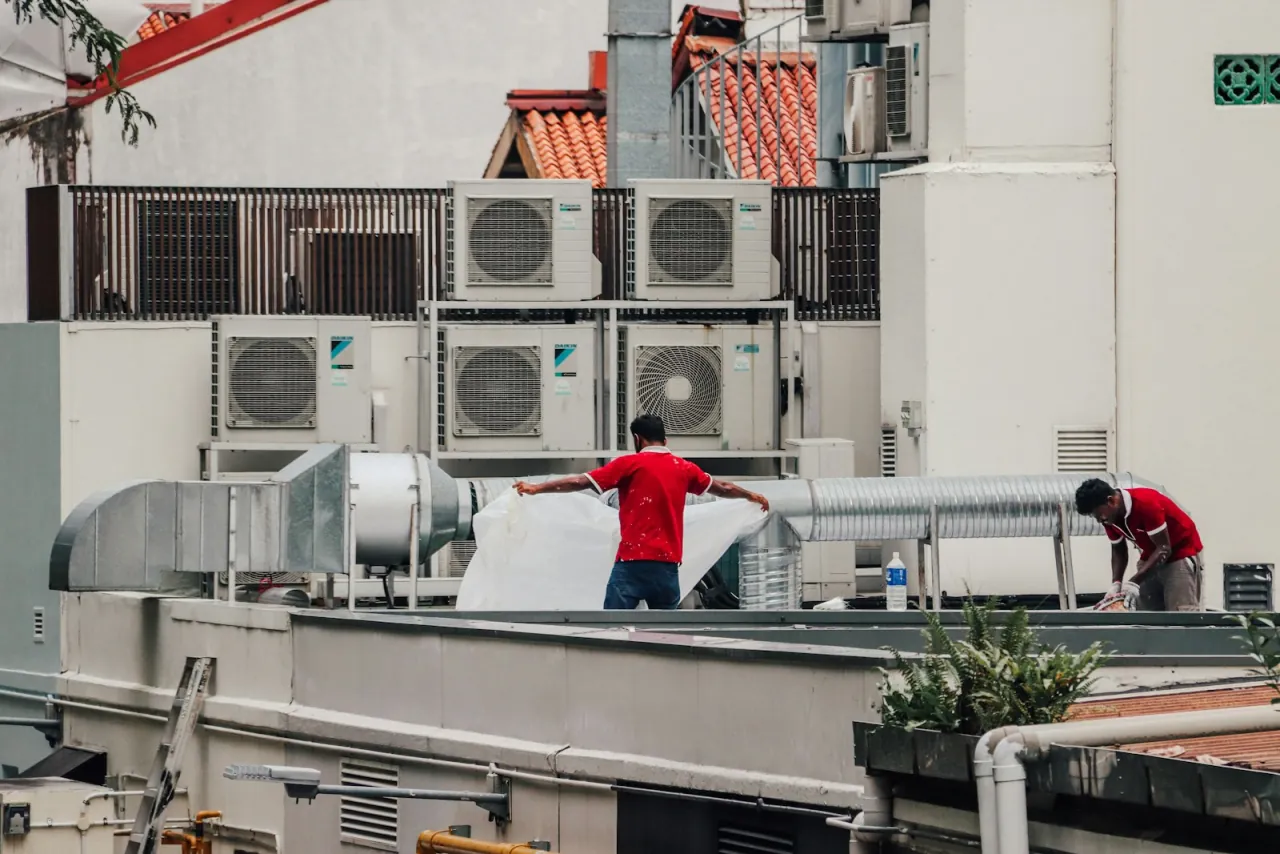 An HVAC crew working on a rooftop unit